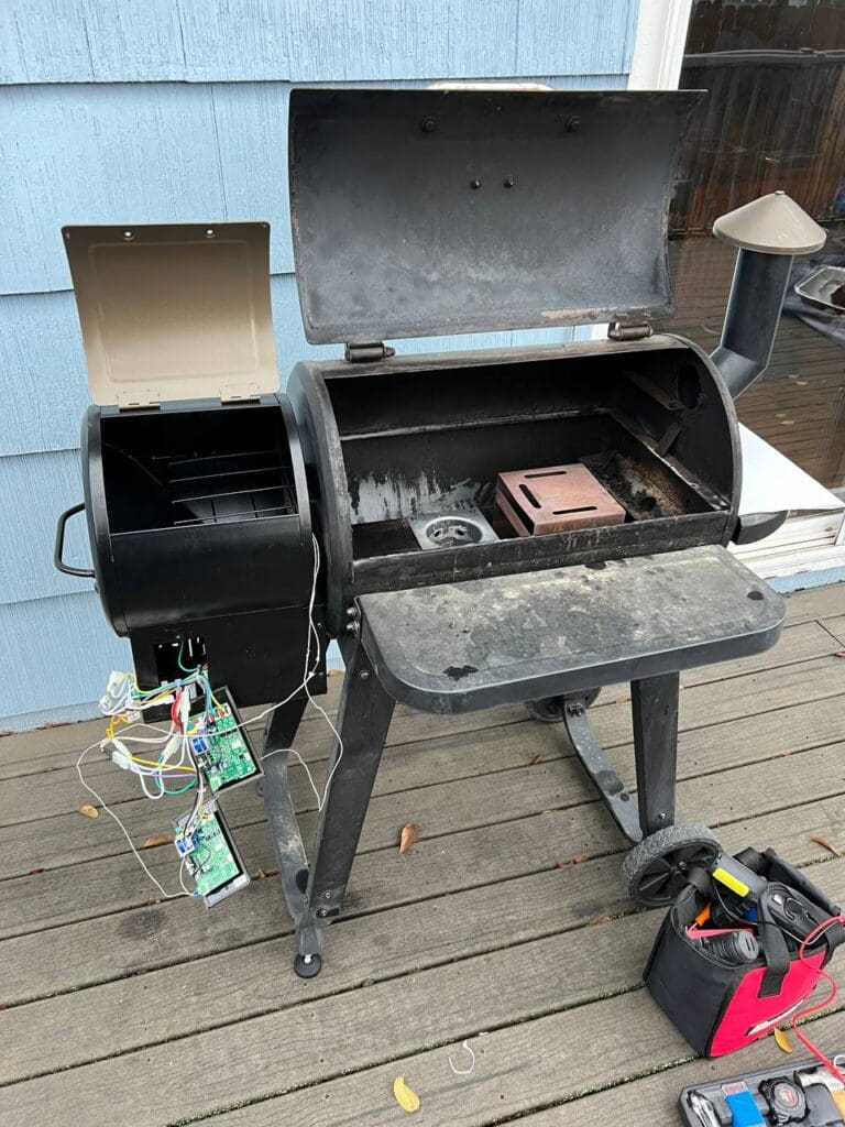 Pellet-fed appliance with its control board exposed for repair